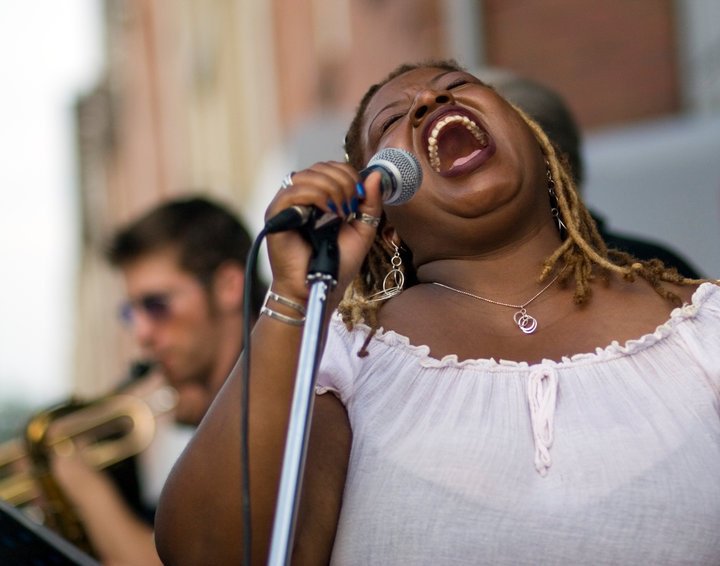Carolyn Thompson performing on stage with a microphone